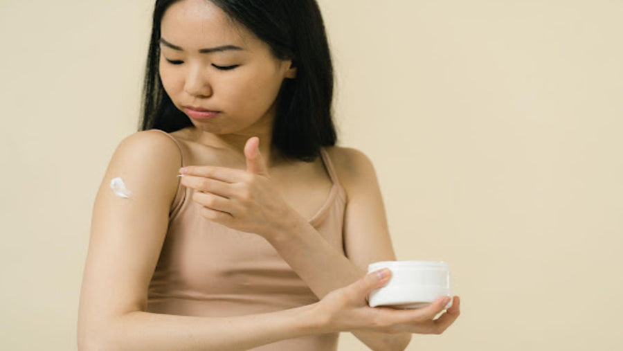 Woman putting cream on her arm